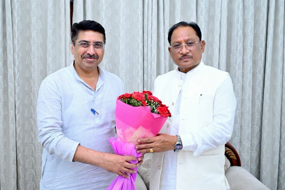 Deepak Mhaskey exchanging a bouquet of flowers with a senior public figure during an official courtesy meeting.