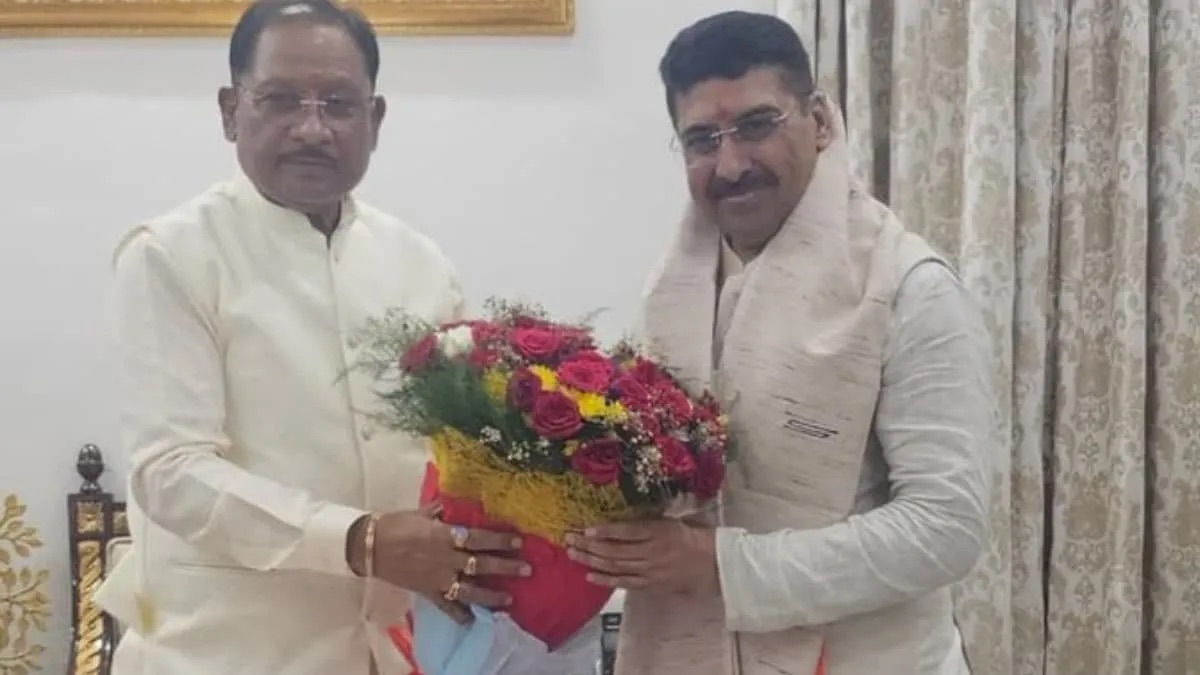 Deepak Mhaskey receiving a bouquet of flowers from a senior leader at an indoor felicitation.